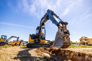 Compact Excavator moving mud on jobsite
