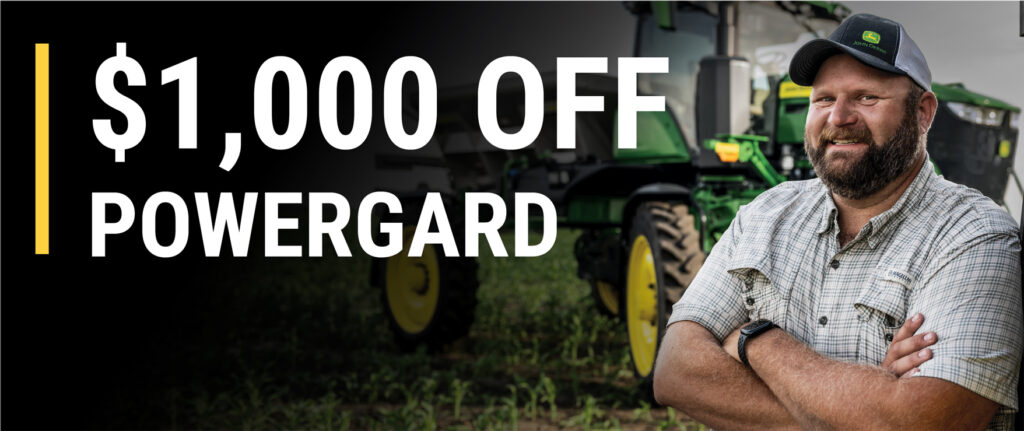 Man in cap and checkered shirt standing before green tractor in field with text "$1,000 OFF POWERGARD"