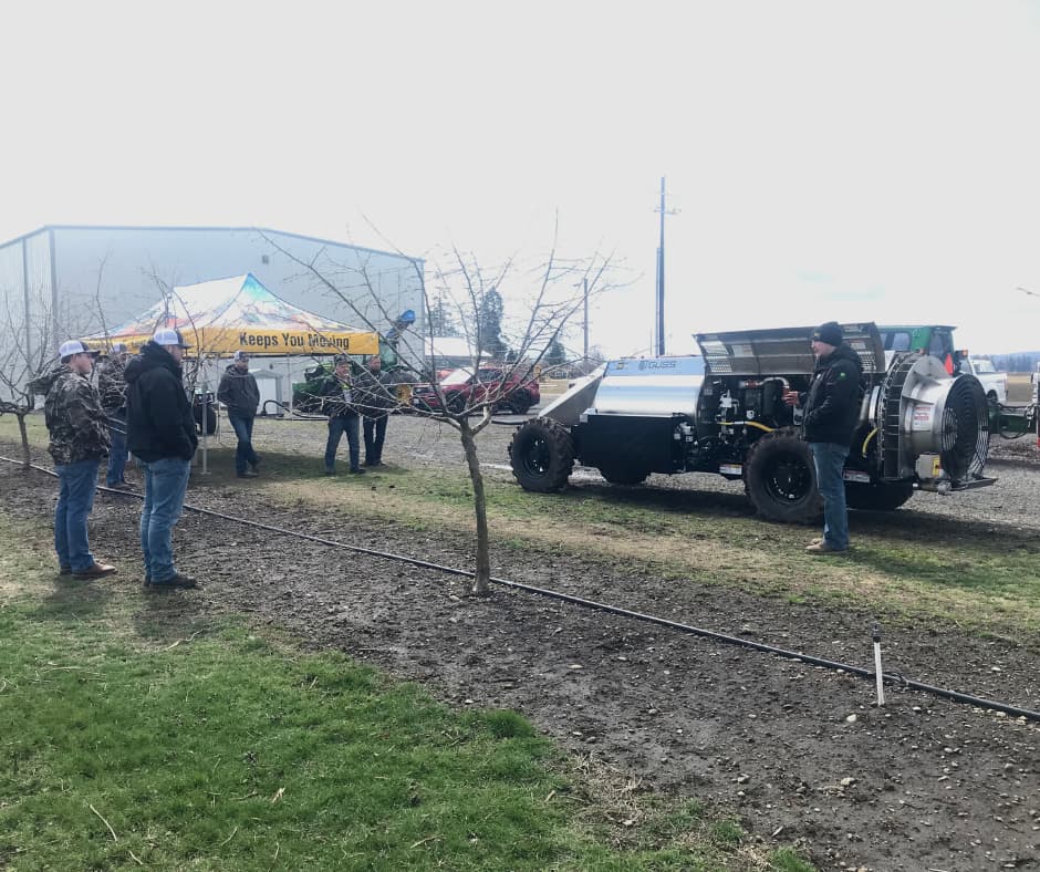 Vintage race car displayed at outdoor event with spectators and yellow tent in background.