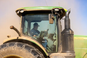 Farmer using John Deere precision agriculture display for data-driven field management